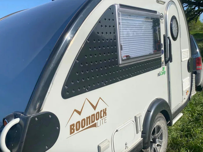  parked in a wooded area. Great for outdoor adventures.|Explore the outdoors with this teardrop nuCamp Boondock Lite **rv rental**