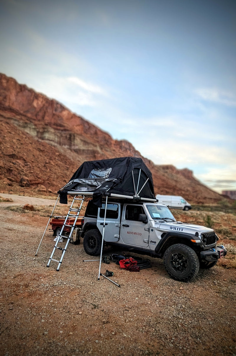  with toilet paper on sand.|An RV rental alternative: a Jeep with rooftop tent & privacy awning set up for scenic off-road camping.|RV rental Jeep with rooftop tent & privacy shelter for off-road camping adventures under a blue sky.|Jeep RV rental with rooftop tent & privacy screen set up for overlanding and camping in a sunny forest.|Silver Jeep Wrangler with a rooftop tent deployed — photo 2