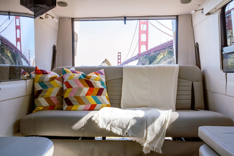 Step into comfort: an RV rental with cozy seating, colorful pillows, and a breathtaking Golden Gate Bridge view. — photo 5