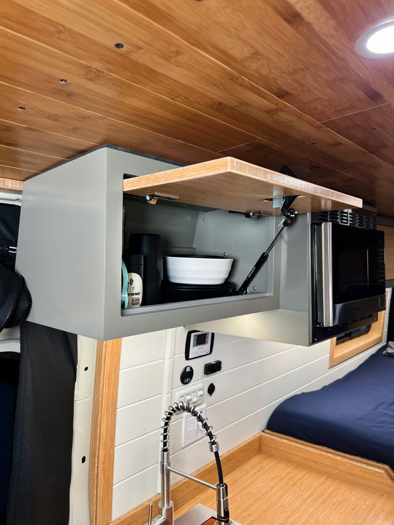  fridge & pull-out table. Cozy bed & sleek design.|Modern RV rental kitchen with induction cooktop — photo 12