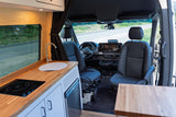 Inside this rv rental, a sleek camper van features a wooden kitchenette with sink/cooktop and a spacious driver's cockpit.