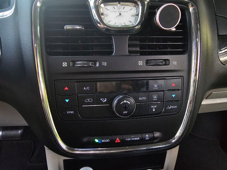 Dashboard controls: HVAC, temperature, rear climate, and power outlet buttons, found in a car or RV rental.