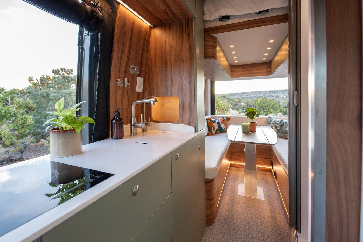 Stylish RV rental interior with a modern kitchen, cozy dining area, and scenic views through the large window. — photo 14