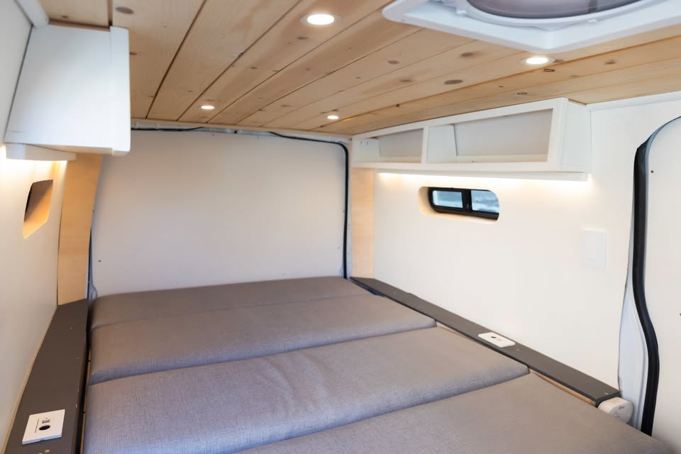  on a dirt road at sunset in a vast desert with mountains.|Inside a stylish RV rental: a camper van kitchenette with wood counter — photo 3