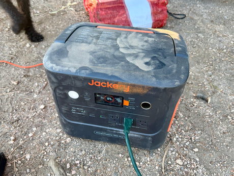 A dusty Jackery Explorer 1000 Plus portable power station, 89% charged, in an outdoor setting, ideal for rv rental or camping.