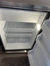 The clean, empty refrigerator interior of an rv rental, featuring wire shelves and clear bottom bins, ready for use.