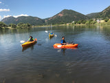 Three young people kayaking on a scenic mountain lake. Perfect outdoor recreation for an RV rental trip!