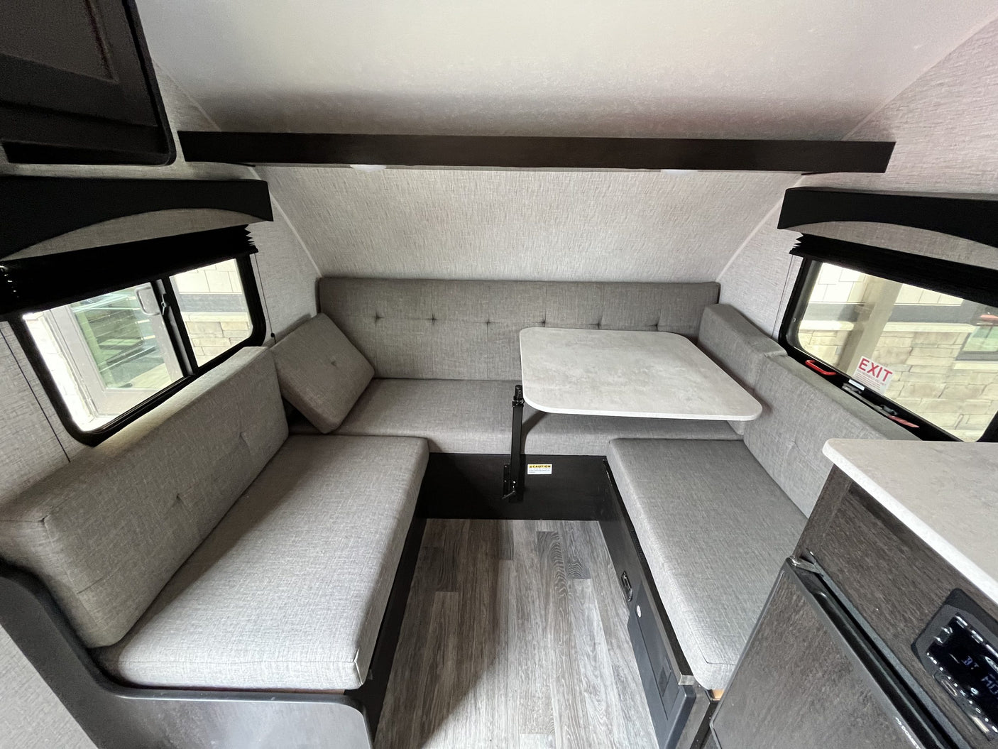 Cozy RV rental interior with a U-shaped dinette, central table, and comfortable seating for an ideal getaway.