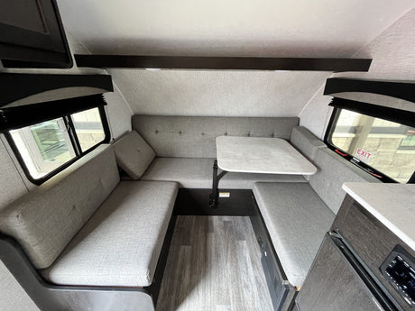 Cozy RV rental interior with a U-shaped dinette, central table, and comfortable seating for an ideal getaway.