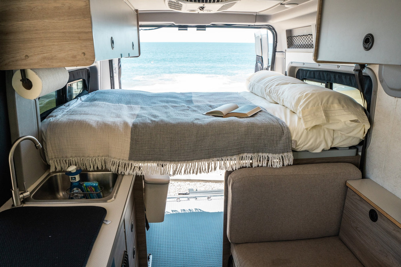 Experience the ultimate RV rental! This modern camper van offers a cozy bed, kitchenette, and breathtaking ocean views. — photo 2