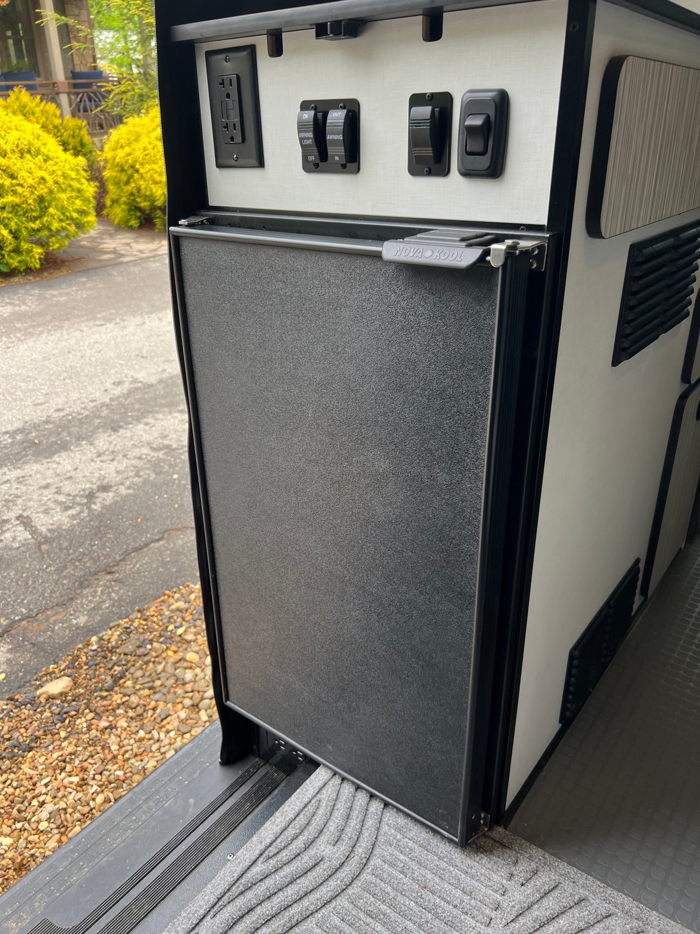 This rv rental features a Nova Kool fridge, GFCI outlet, and awning controls neatly integrated into the camper's design.