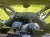 Inside this RV rental van: A clean, modern cockpit with a steering wheel, dashboard, and comfortable front seats.
