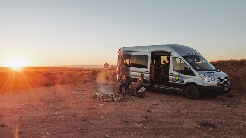  parents with coffee by the open rear doors in a desert landscape.|RV rental adventure: A Wandervans van — photo 3
