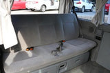 RV rental interior: comfy gray bench seat with under-seat storage, likely converts to a bed. Perfect for travel.