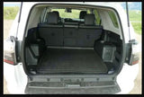 SUV's rear cargo area, ready for adventure! Black protective mat on floor, rear seats up. A great alternative for an RV rental trip.