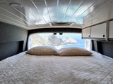 RV rental comfort: Enjoy breathtaking ocean views and rocky coastal mountains from your cozy bed in this camper van.