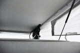 RV rental pop-top interior showing raised roof, black lift mechanism, and light canvas walls. Offers comfortable headroom.
