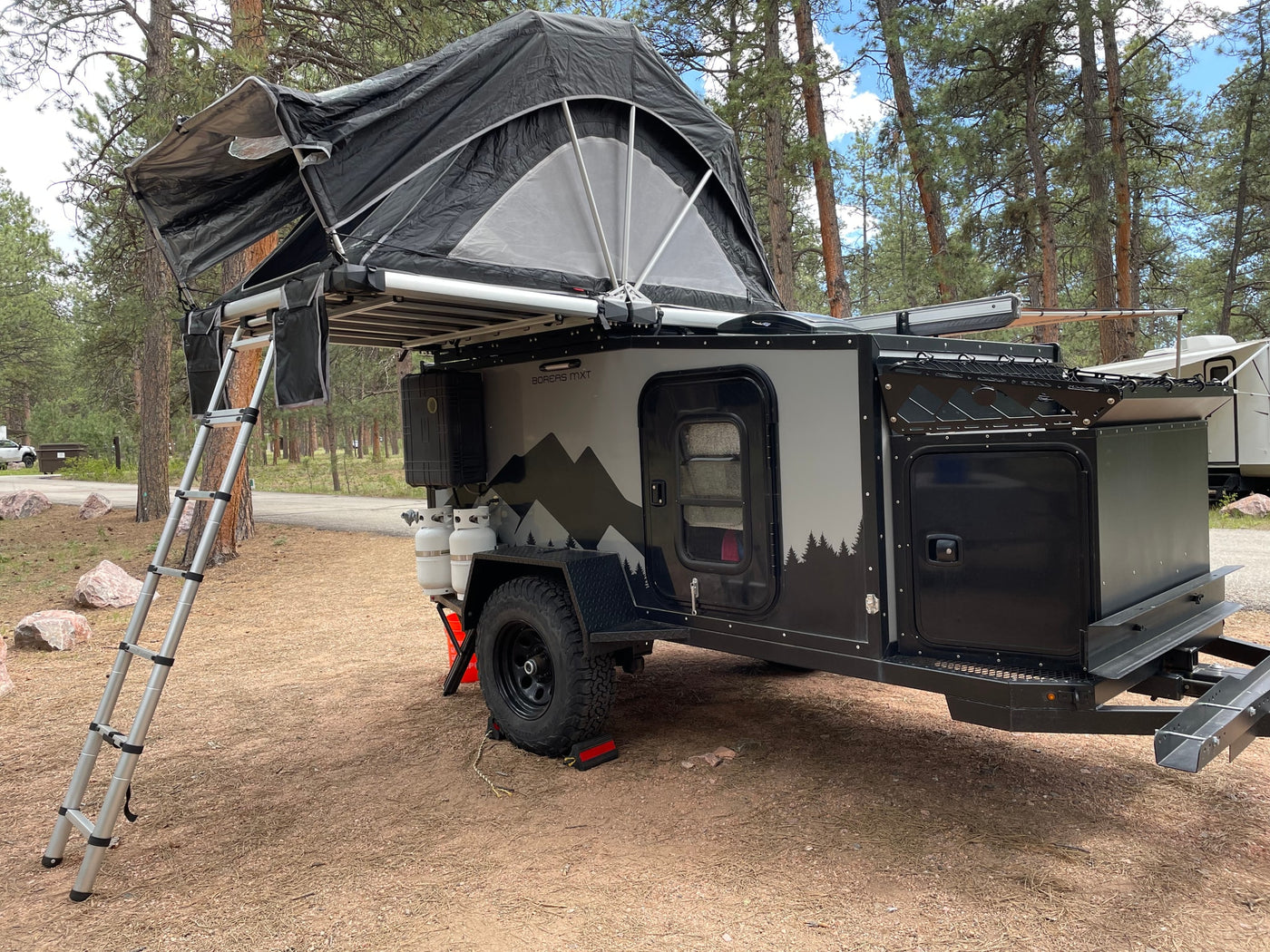 Off-road camper trailer RV rental with rooftop tent, set up for camping among pine trees. Ideal for outdoor adventures. — photo 12