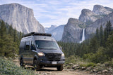 Explore stunning nature with this RV rental. A custom campervan in Yosemite Valley, backed by El Capitan, Half Dome, and a waterfall.