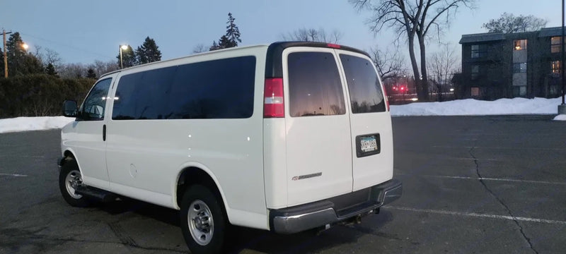  parked outside in a winter setting at dusk.|White passenger van with open side door — photo 4