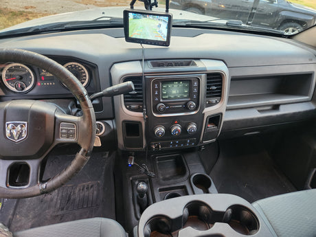 A Ram truck dashboard with an added rearview camera screen displaying a yard. Essential for an RV rental experience or towing.