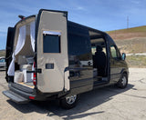 Black Sprinter van converted to an RV, doors open to reveal its cozy interior and a dog. Perfect for an rv rental adventure.