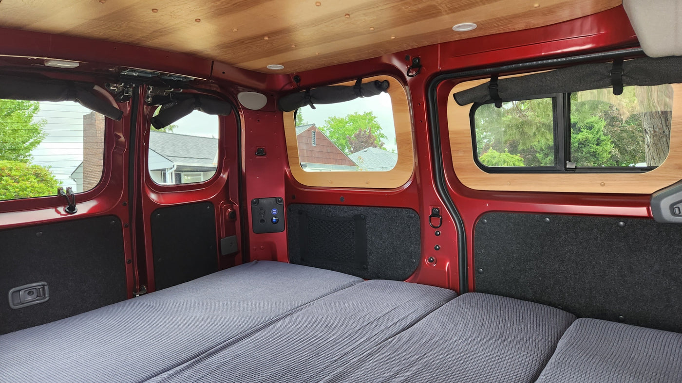 Cozy camper van interior for your next RV rental adventure, featuring a comfy bed, custom windows, and a wooden ceiling. — photo 10
