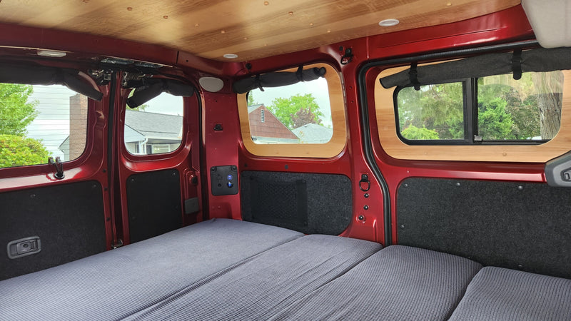 Cozy camper van interior for your next RV rental adventure, featuring a comfy bed, custom windows, and a wooden ceiling. — photo 10