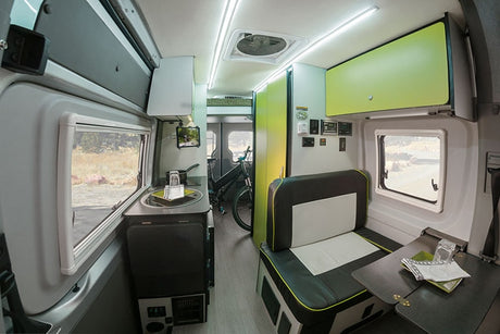 Bright and modern RV rental interior showing a kitchen, cozy dinette, and bike storage area, ready for adventure.
