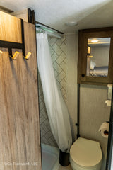 Compact RV rental bathroom with shower, toilet, and vanity, designed for efficient use of space.