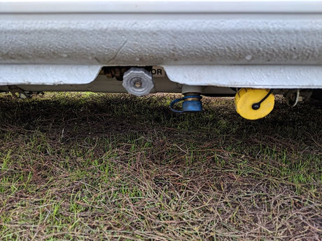 Inspecting rv rental utility points: gas, water, and drain connections clearly visible below.