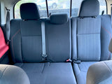 View of the dark fabric rear seats inside an RV rental, featuring three headrests, seatbelts, and a rainy window.