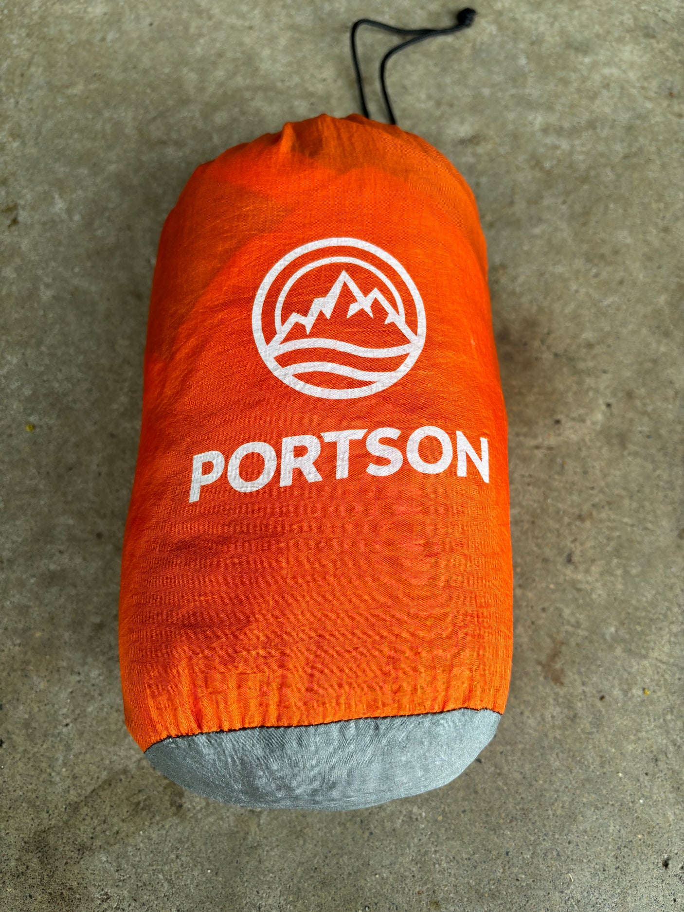 Bright orange PORTSON stuff sack, great for organizing essentials on your next **RV rental** or camping trip.