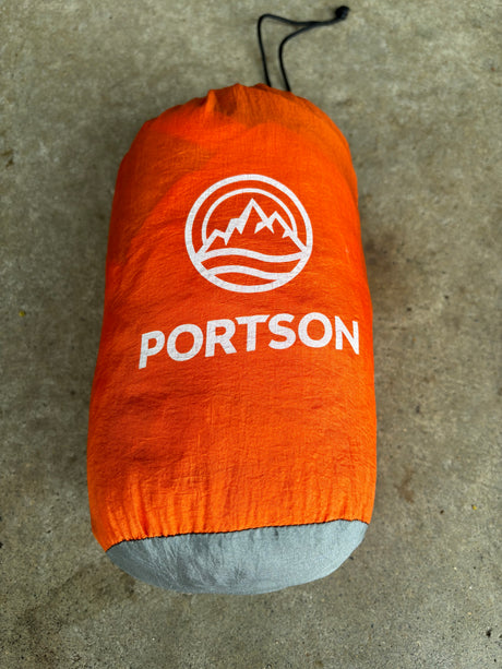 Bright orange PORTSON stuff sack, great for organizing essentials on your next **RV rental** or camping trip.