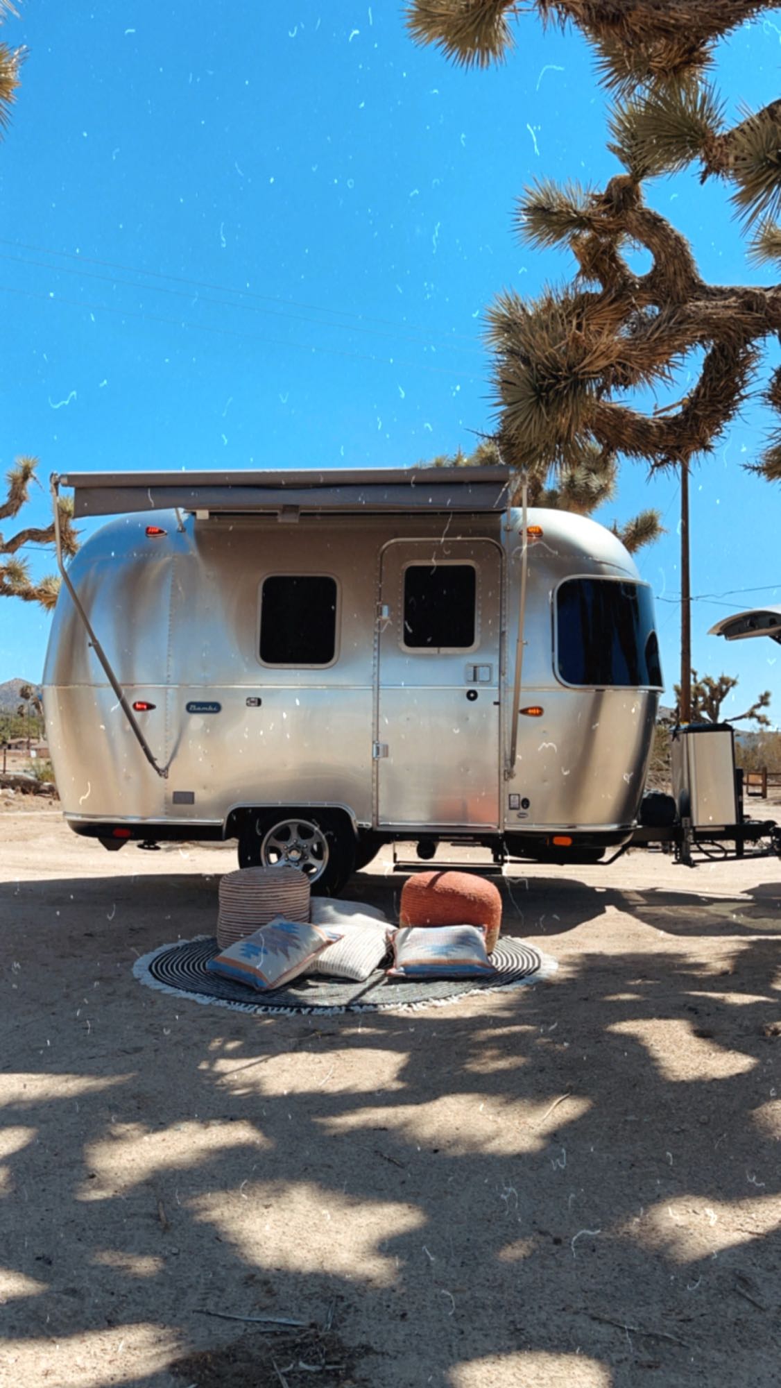  ideal for an RV rental adventure in Joshua Tree.|Cozy rv rental interior with sun-patterned bedding — photo 3