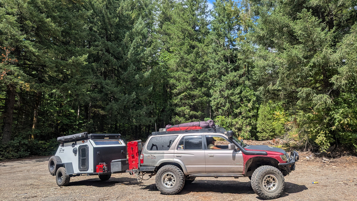 Off-road SUV towing an overland camping trailer through a dense forest. A rugged RV rental option for adventure travel. — photo 13