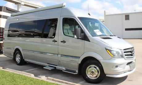 Silver Mercedes-Benz Sprinter RV rental van, ideal for travel. Parked outside on a sunny day.