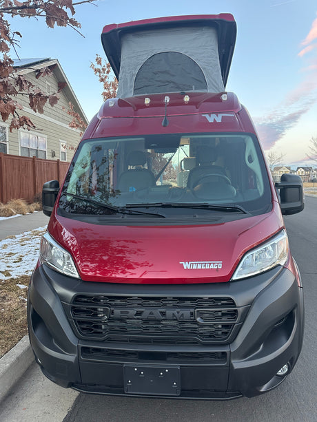 Front view of a red Winnebago pop-top camper van, ideal for an unforgettable RV rental trip.