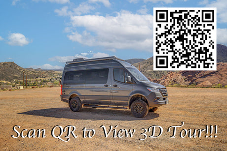 Gray adventure RV rental parked in a mountainous outdoor setting. Scan the QR code to take a 3D tour of this camper van.
