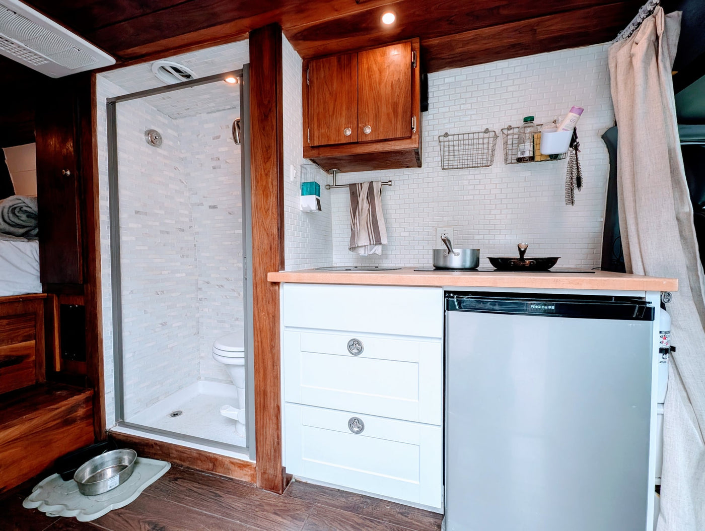  and unique starburst wall decor. Apples on tray.|Inside an RV rental: compact wet bath featuring a toilet — photo 9