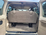 RV rental: Rear view inside a spacious passenger van, featuring the large bench seat & carpeted cargo area.