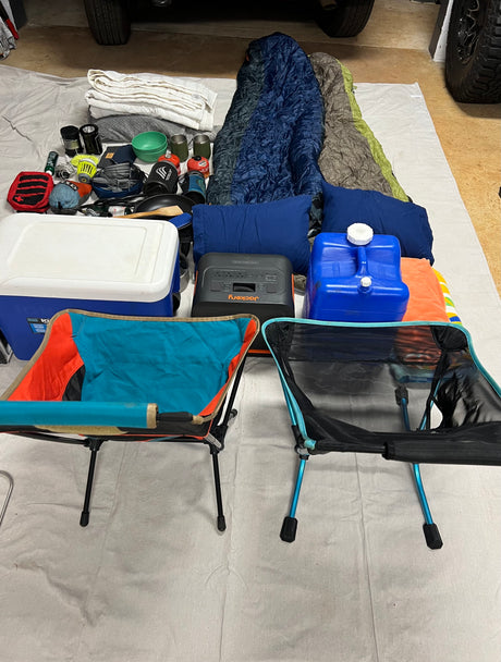 All your camping essentials laid out: cooler, Jackery power station, sleeping bags, chairs, cooking gear – ideal for an RV rental journey.