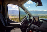 Enjoy expansive mountain views from this RV rental's driver's seat, overlooking a valley town. Perfect for a scenic road trip.
