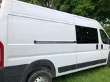 White camper van, perfect for an RV rental. Side view shows tinted windows and a side door track, parked on green grass.