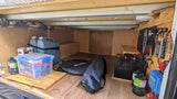 Inside an RV rental: organized under-bed storage with water, propane, gear, and a robust off-grid power system.