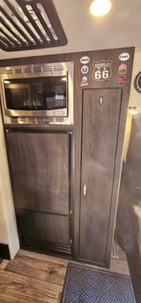 Compact RV rental kitchenette featuring a microwave, refrigerator, and ample storage, perfect for road trip adventures.