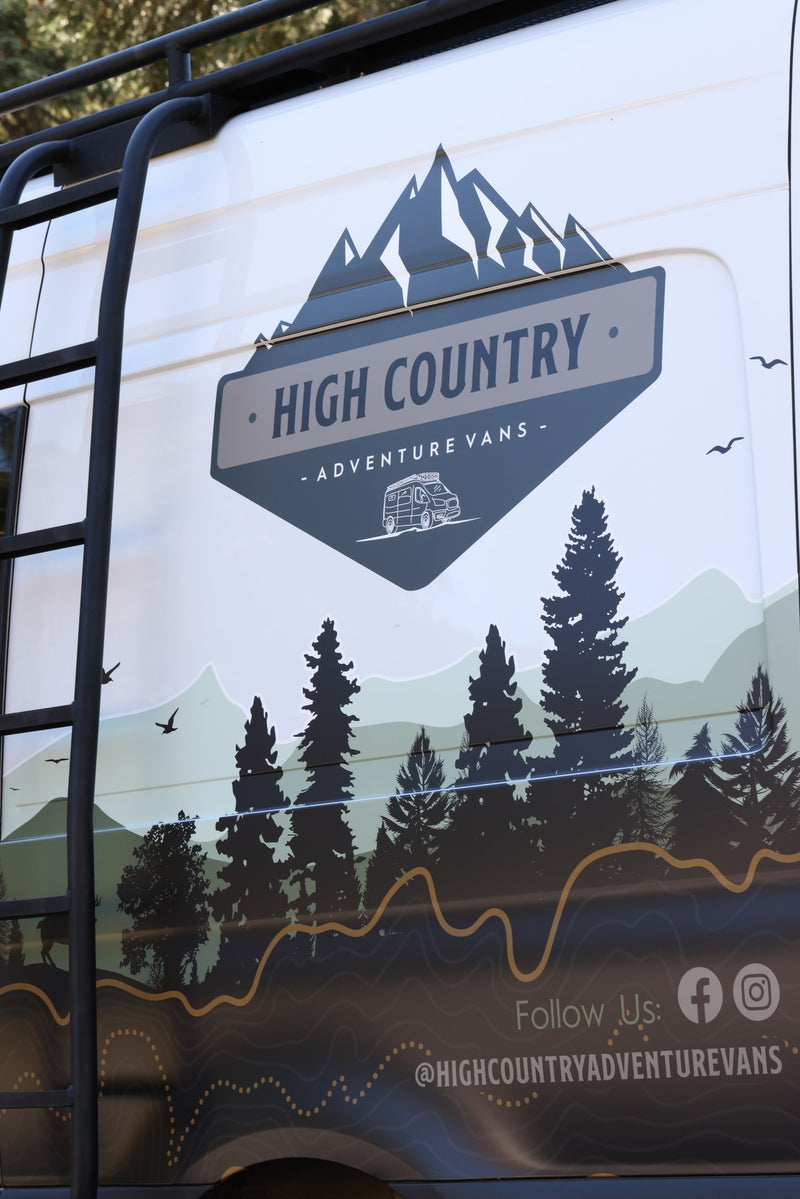 Side of a High Country Adventure Vans RV rental, featuring a custom graphic with mountains, trees, and social info. — photo 6