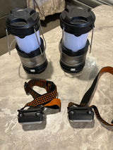 Essential gear for your RV rental adventure: two compact lanterns and two headlamps on a textured surface.