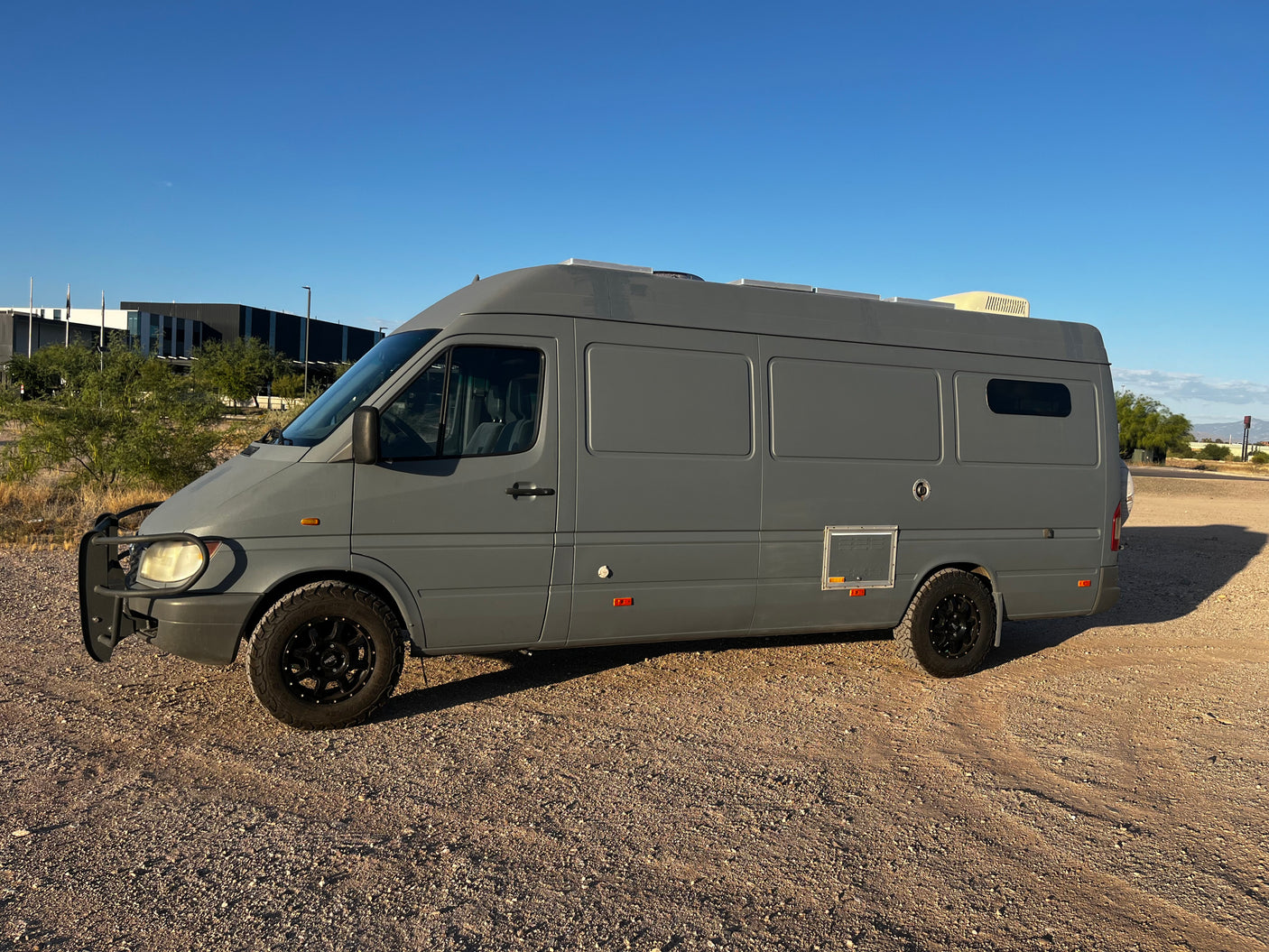 This rugged gray Sprinter camper van, modified for adventure, could be an excellent RV rental choice for your travels.