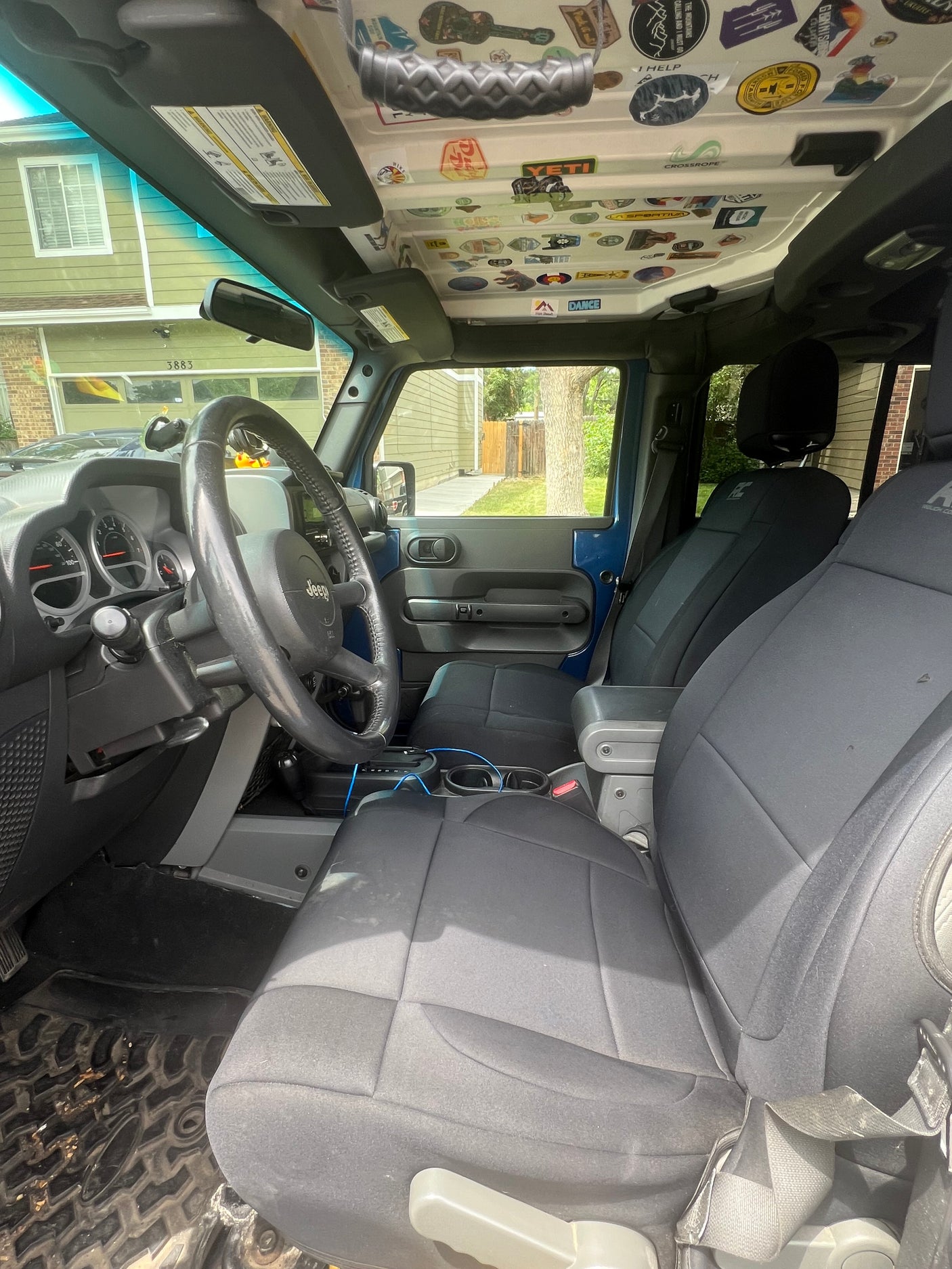 Inside a personalized blue Jeep, decked with adventure stickers on the roof. Perfect for an outdoor trip, like an rv rental journey.